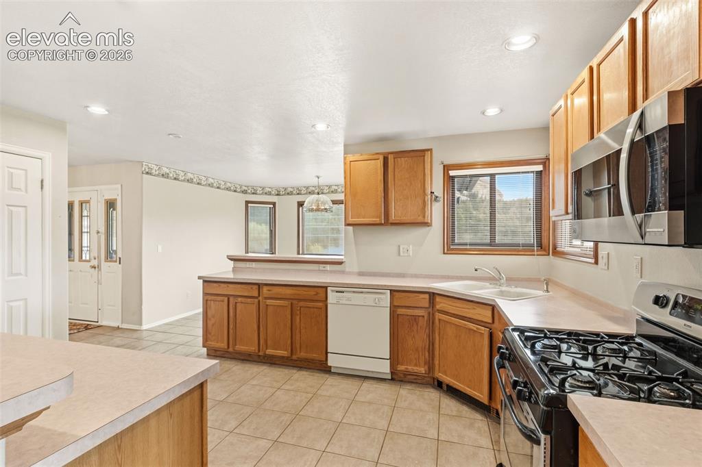 Image 10 of 29: Country style kitchen with generous cabinet space, gas range, recessed ligh
