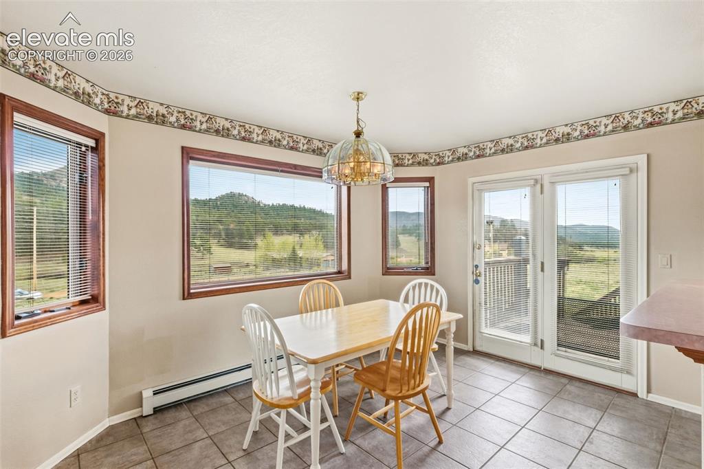 Image 12 of 29: Eat in dining area surrounded by windows with walkout access to the deck an