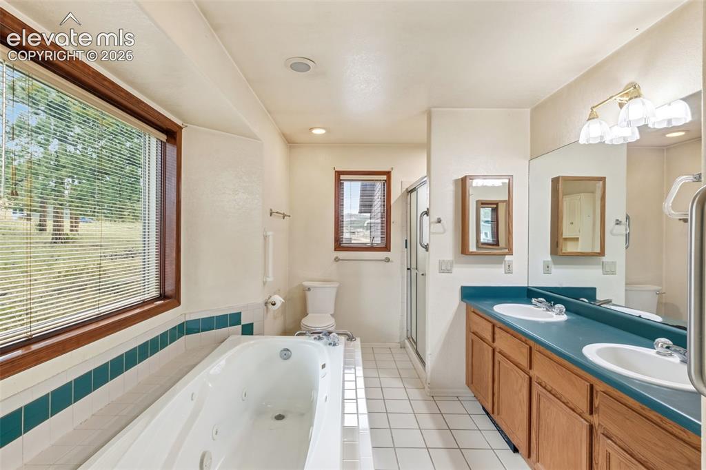 Image 17 of 29: Five piece primary bathroom with dual vanity, jacuzzi tub, walk in shower,
