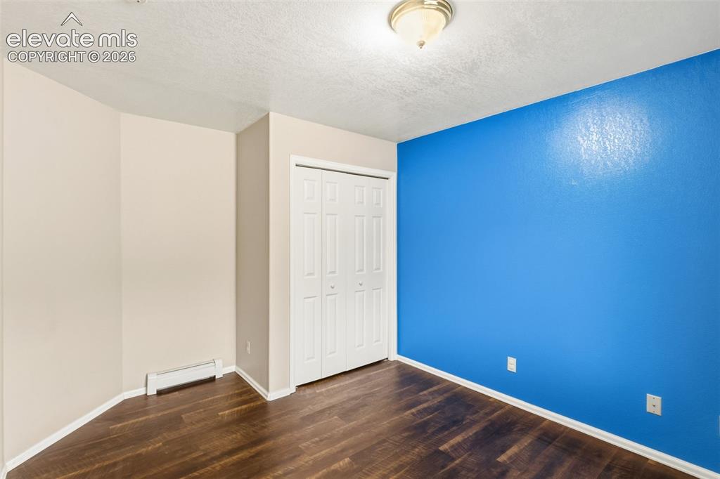 Image 18 of 29: Secondary bedroom with LVP flooring, closet storage, and flexible space for