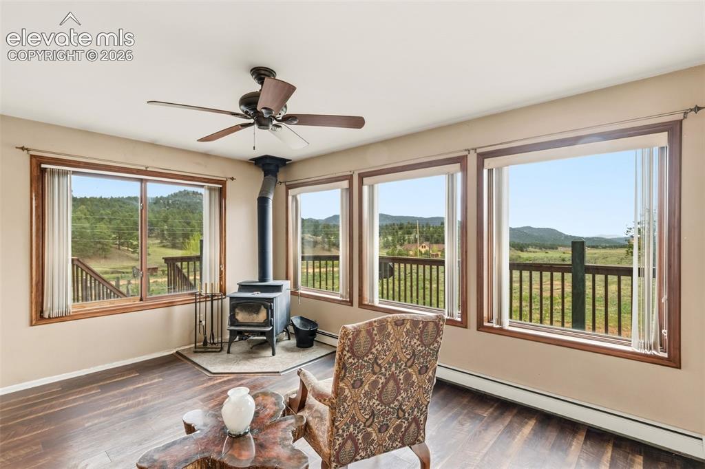 Image 8 of 29: Window wrapped office and den space with woodburning stove, expansive mount