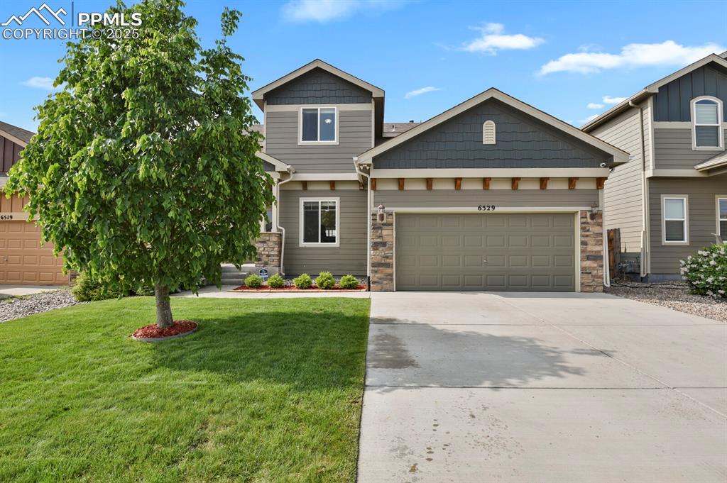Caption: Beautifully landscaped yard with beautiful flowers, lush green grass and trees and an automatic spri
