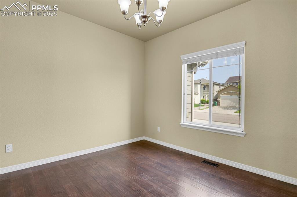 Image 16 of 33: Beautiful spacious dining room with wood floors and views of nature.