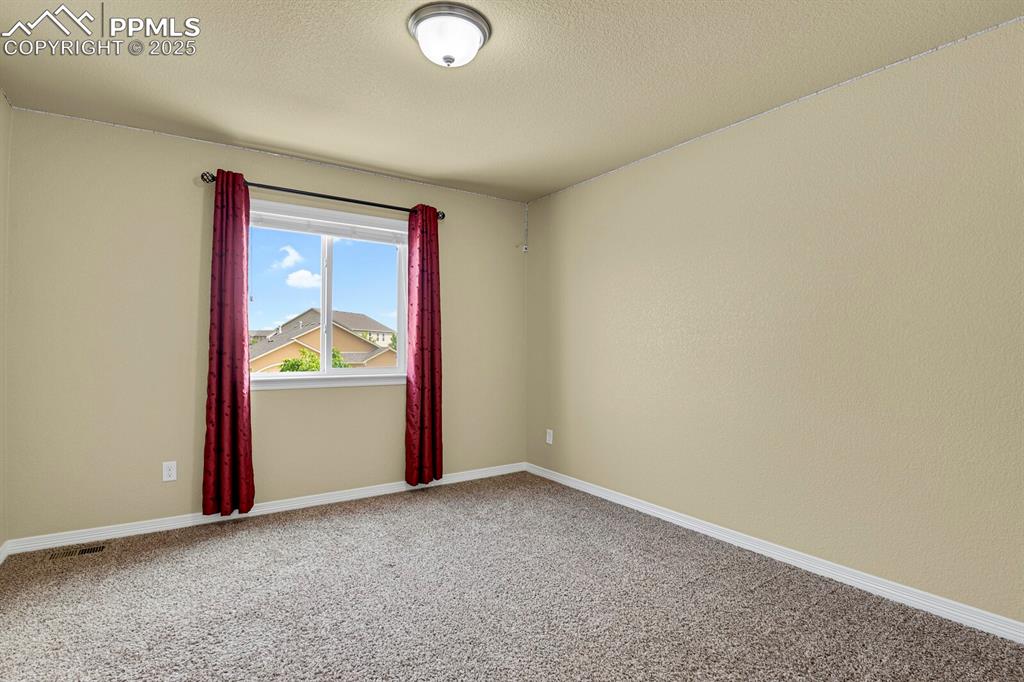 Image 26 of 33: Spacious upper level bedroom with walk in closet and views. 