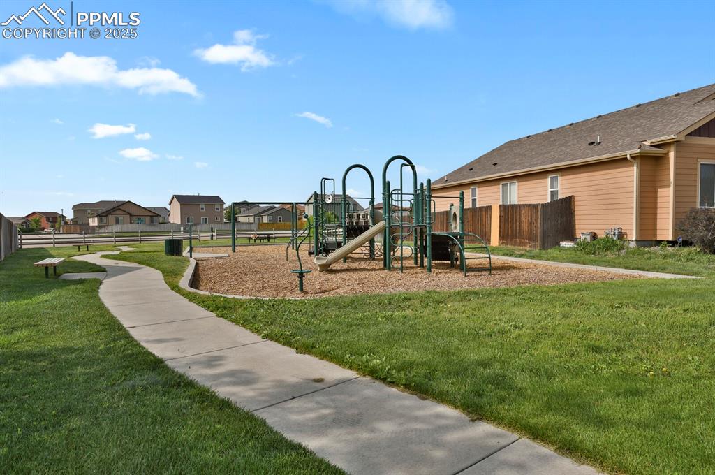 Image 6 of 33: Neighborhood playground with walking trails, benches, tables just one house