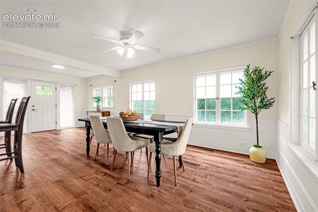 Image 12 of 50: Wood-finish flooring throughout, white paneled wainscoting, and white trim 