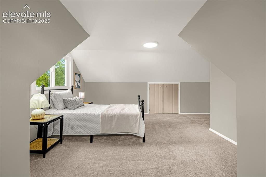 Image 21 of 50: Attic space featuring sloped ceilings, a window, flush-mount lighting, and 