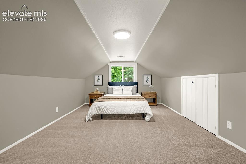 Image 23 of 50: Wall-to-wall carpeting with a neutral finish, vaulted ceiling, recessed win