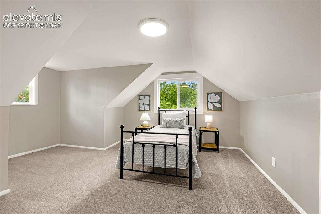 Image 28 of 50: Sloped ceilings, neutral carpet, recessed lighting, and two windows