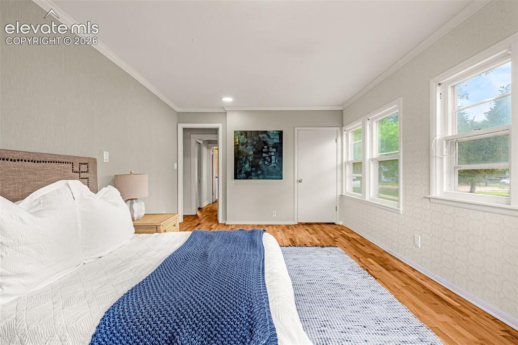 Image 33 of 50: Wood-finish flooring throughout, multiple windows, and crown molding