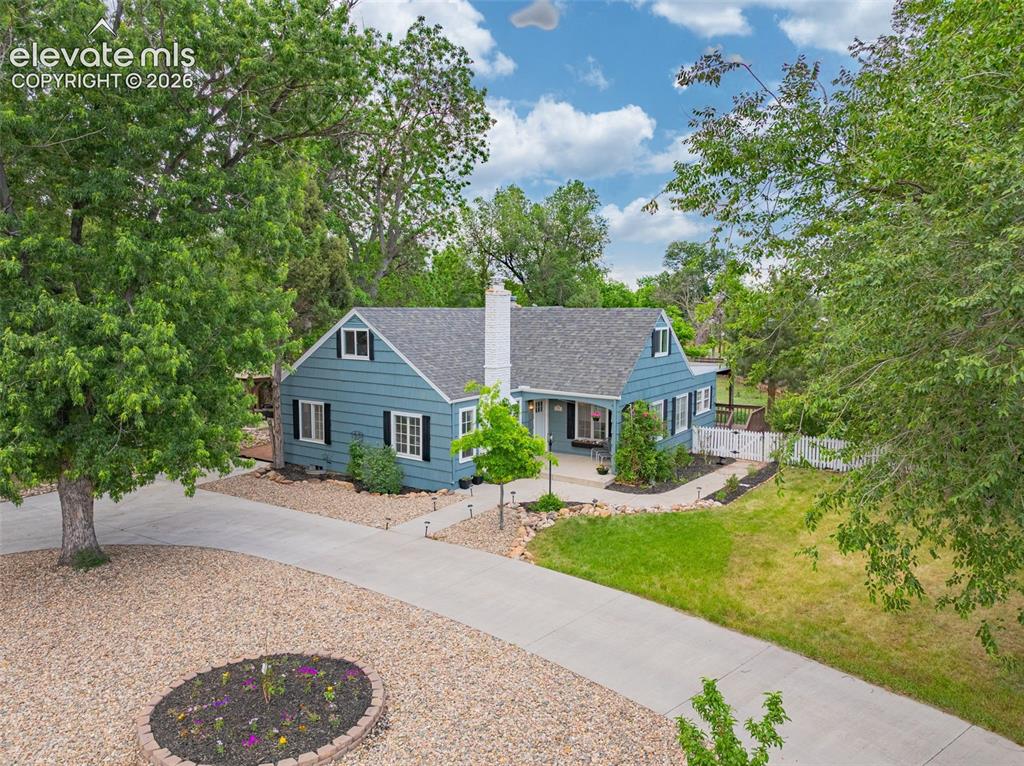 Image 48 of 50: Blue siding exterior with white trim, dark gray roof, and a white chimney