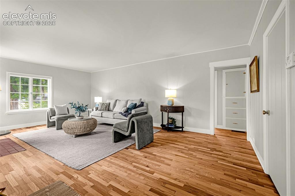 Image 9 of 50: Light-toned hardwood flooring, white trim, and a large multi-pane window