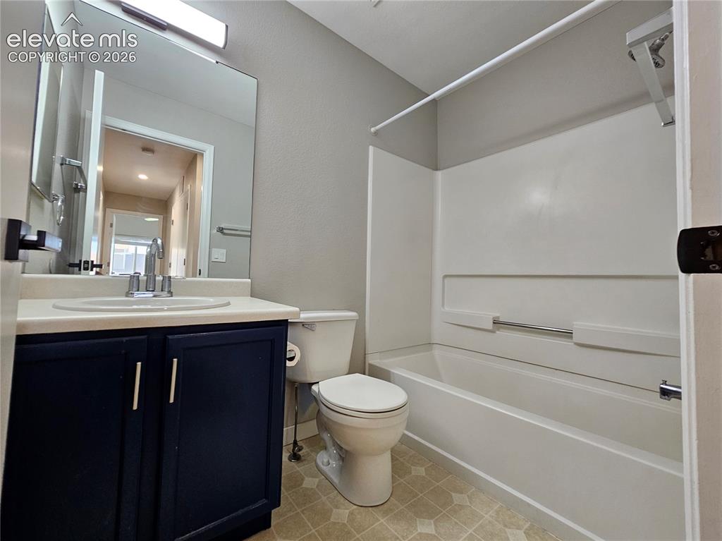 Image 10 of 26: Bathroom featuring a white integrated sink with chrome faucet, dark blue va
