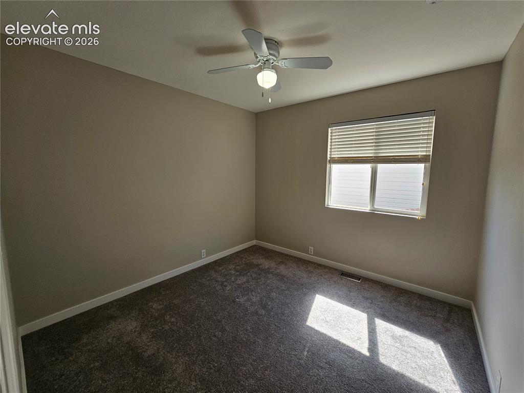 Image 14 of 26: Carpeted room with neutral wall paint and a ceiling fan