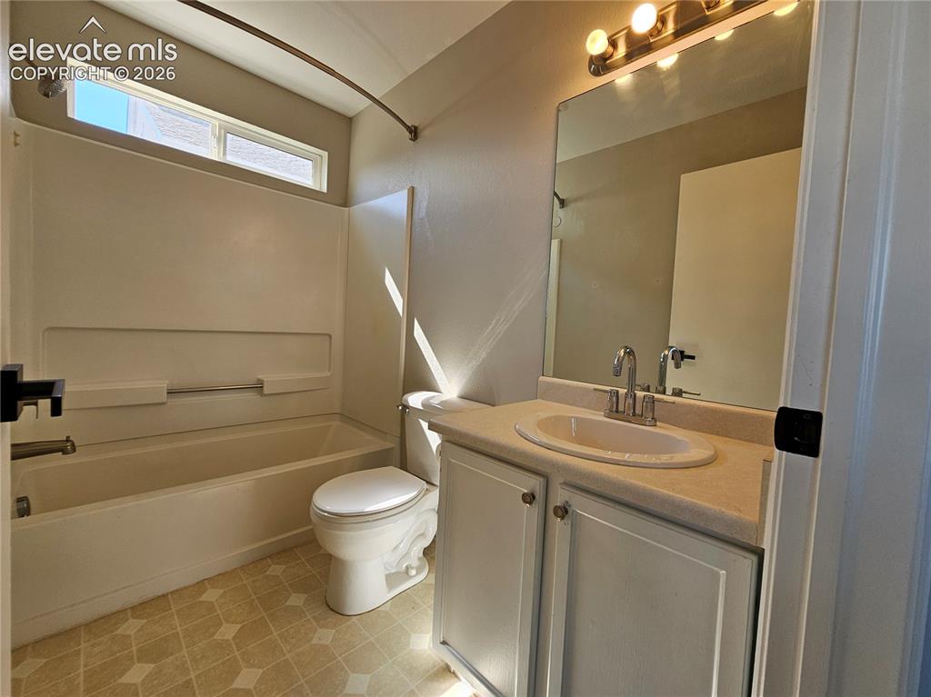 Image 16 of 26: Bathroom featuring a white vanity with an integrated sink, a rectangular mi