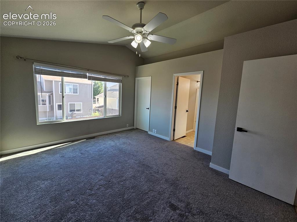 Image 17 of 26: Spacious room featuring vaulted ceilings, a ceiling fan with integrated lig