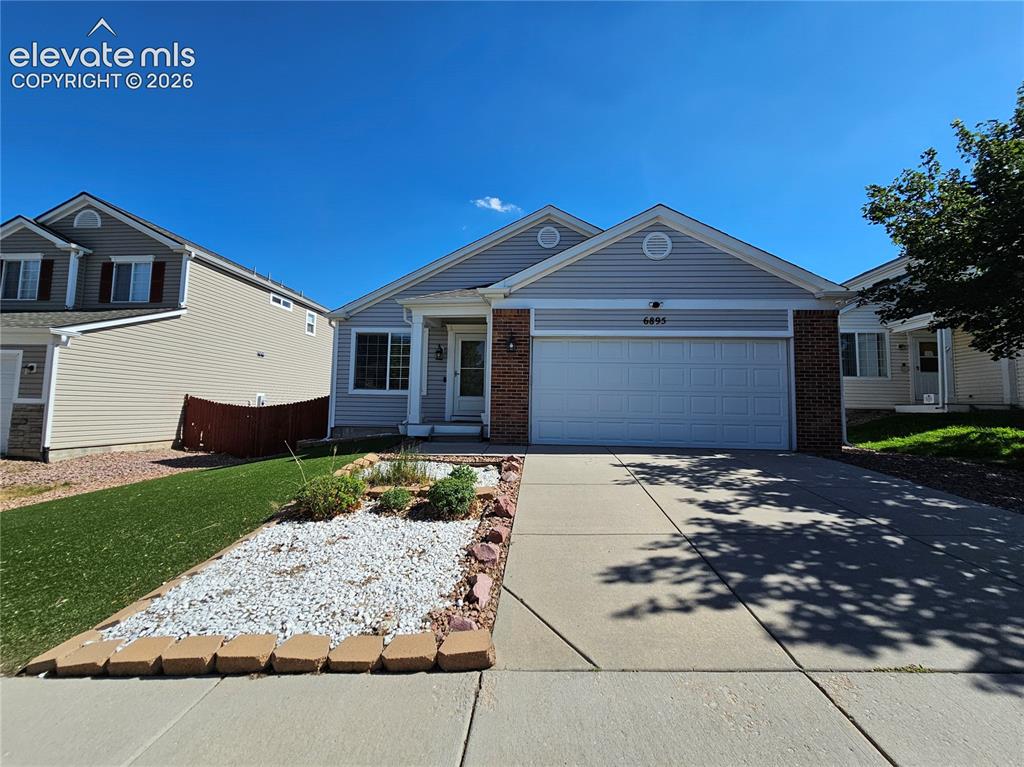Image 2 of 26: Single-story residence featuring light gray siding with brick accents and a