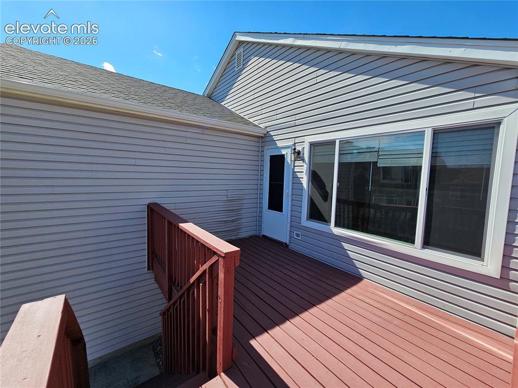 Image 23 of 26: Expansive wooden deck with red-stained planks and matching railings