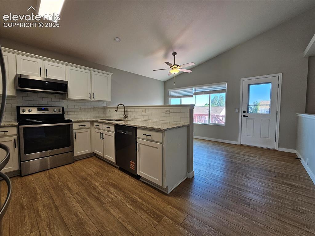 Image 5 of 26: Modern kitchen featuring white cabinetry, stainless steel appliances, and w