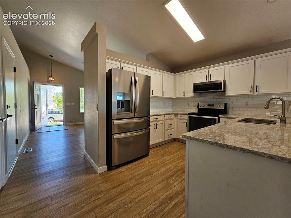 Image 6 of 26: Kitchen featuring white shaker cabinetry, stainless steel appliances, light
