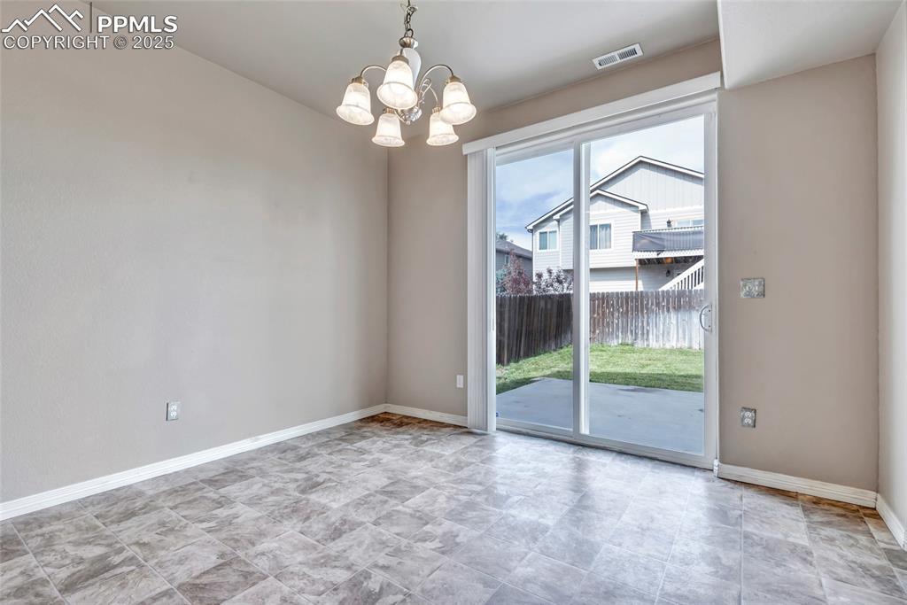 Image 13 of 50: Unfurnished dining area featuring baseboards and a chandelier