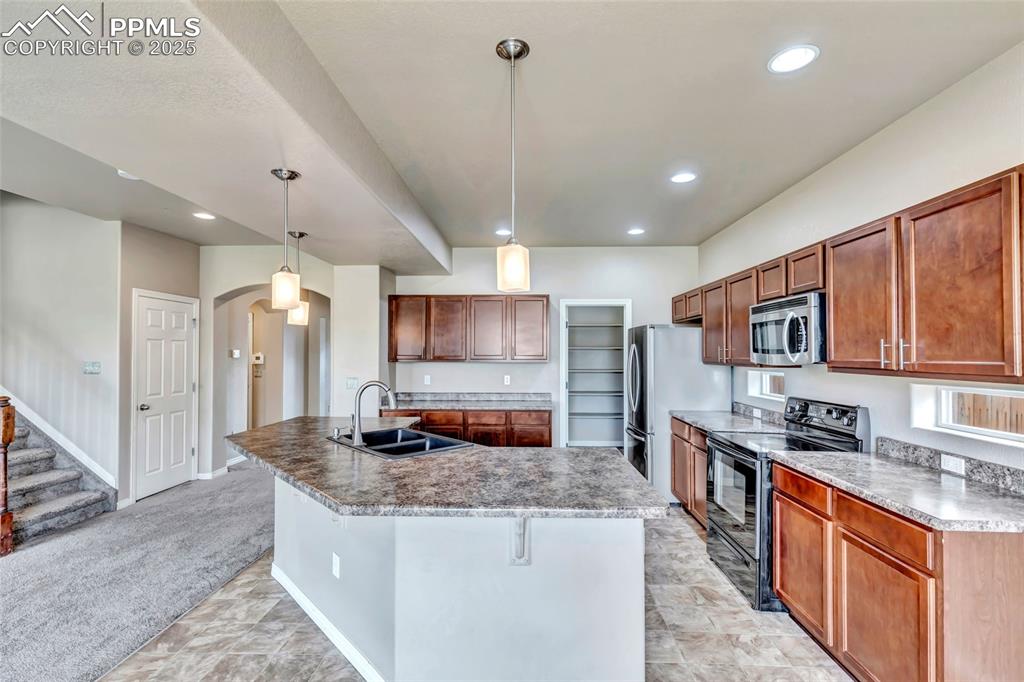 Image 14 of 50: Kitchen with stainless steel appliances, recessed lighting, arched walkways