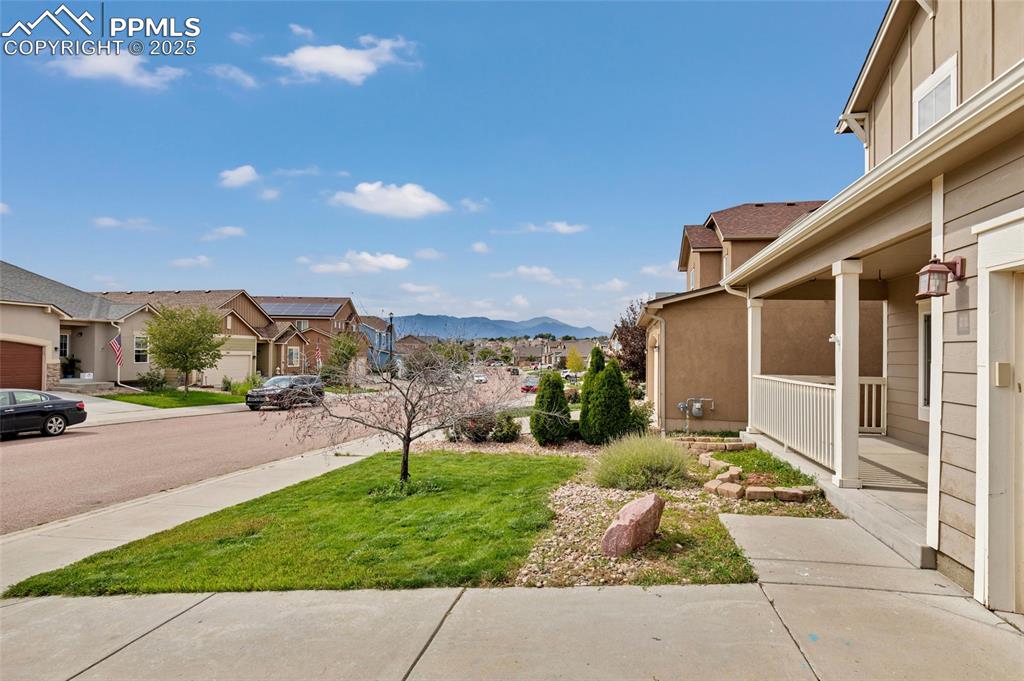 Image 2 of 50: View of green lawn featuring a mountain view, a residential view, and cover