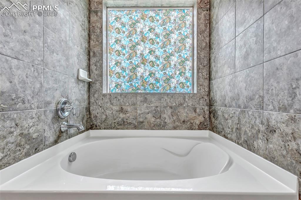 Image 30 of 50: Master bathroom featuring a bath