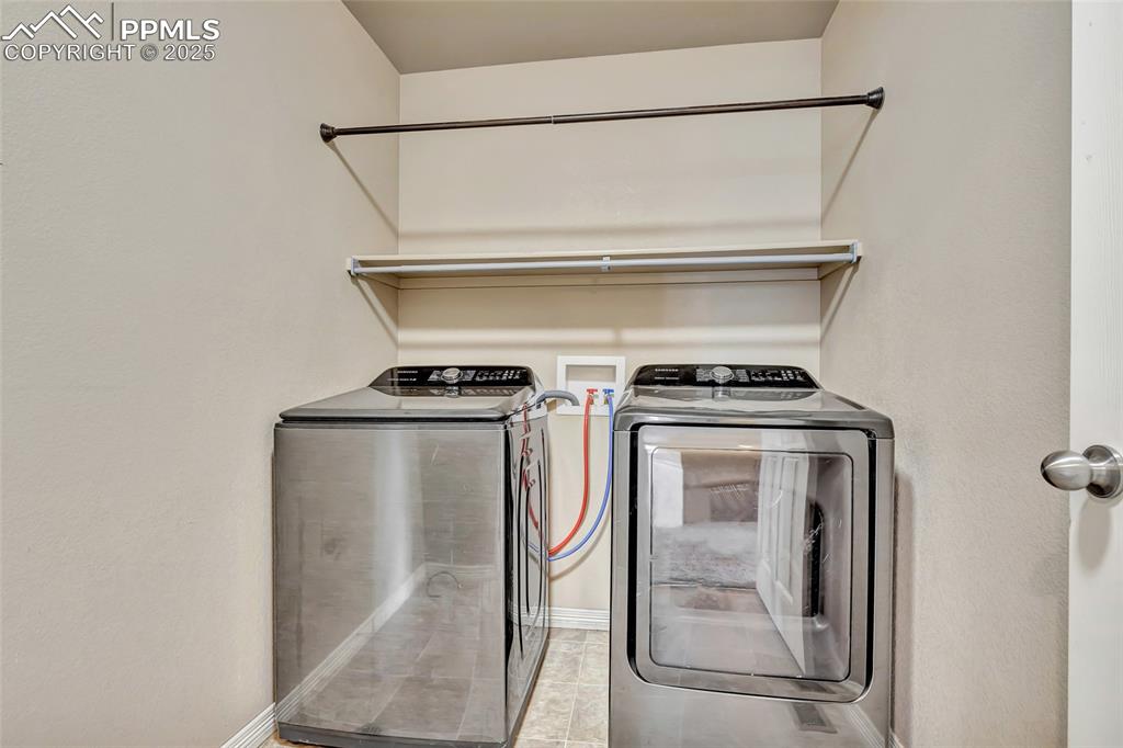 Image 36 of 50: Upper level laundry room with washer and room for storage/folding