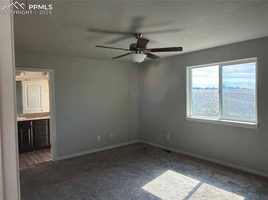Image 5 of 8: Unfurnished bedroom with carpet, ceiling fan, and ensuite bath