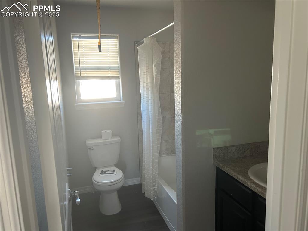 Image 8 of 8: Bathroom with vanity, shower / tub combo, and dark wood finished floors