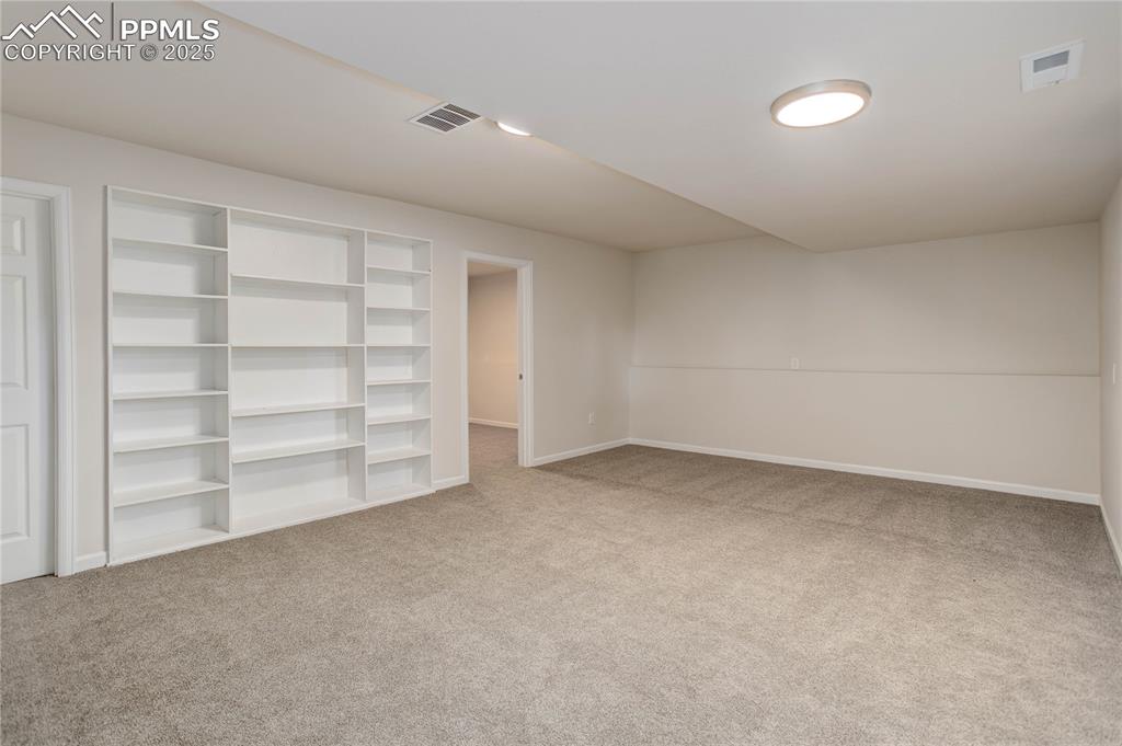 Image 22 of 28: Rec room w/ built-in shelves