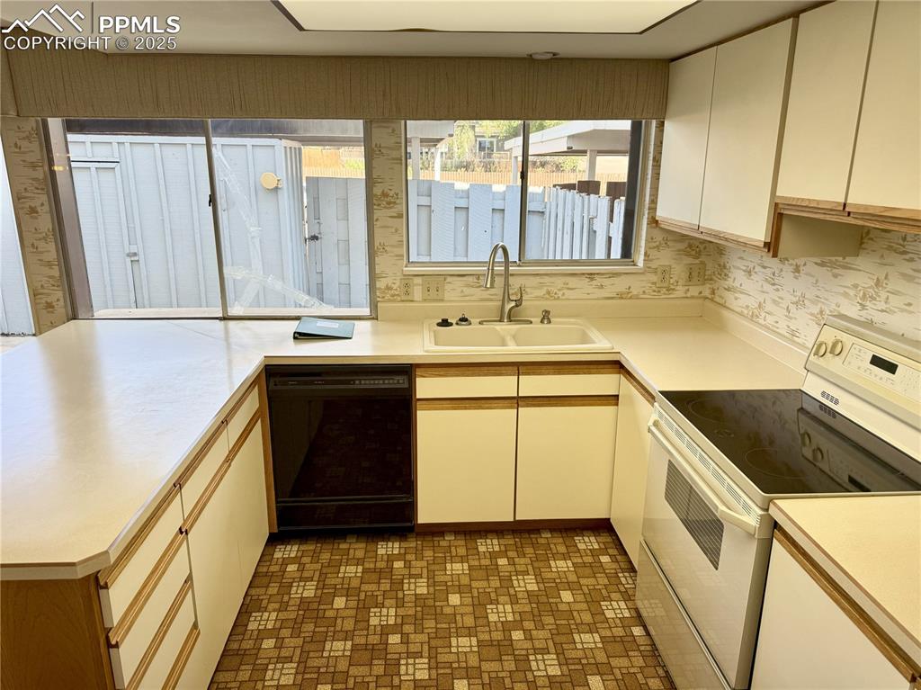 Image 2 of 33: Kitchen overlooking enclosed back patio