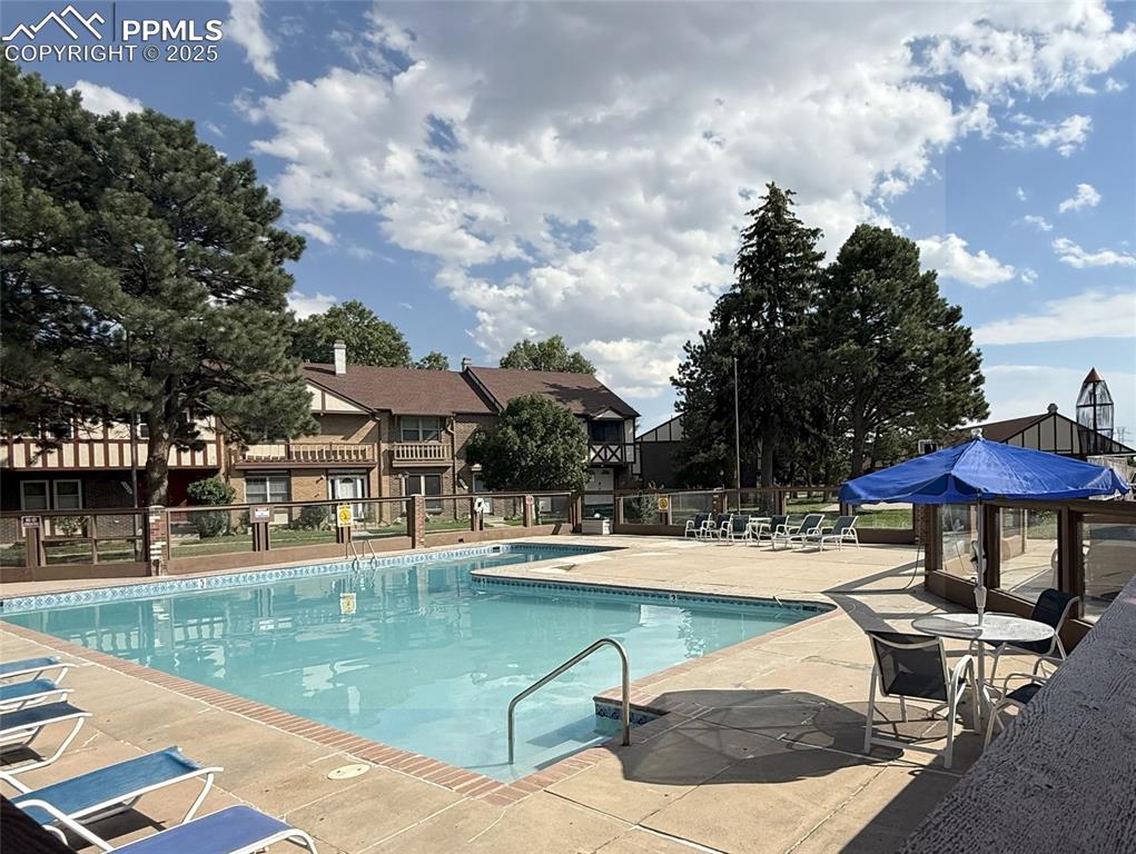 Image 30 of 33: Community pool with a patio area