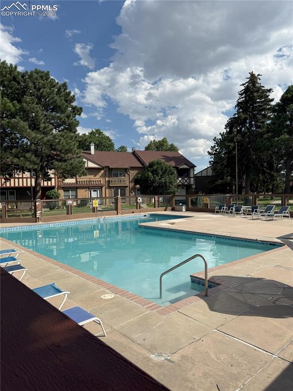 Image 32 of 33: Community pool with a patio