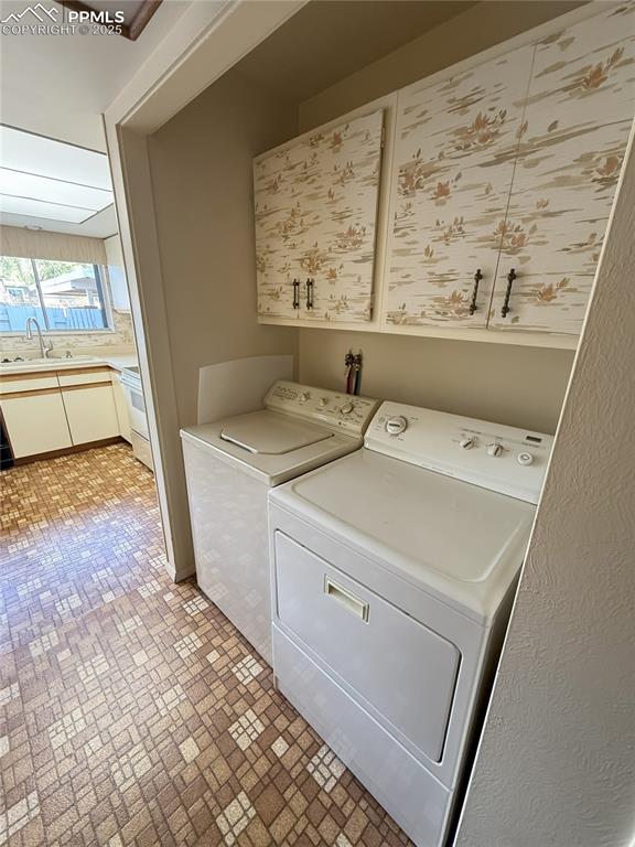 Image 5 of 33: Washroom with brick patterned flooring, washing machine and clothes dryer,