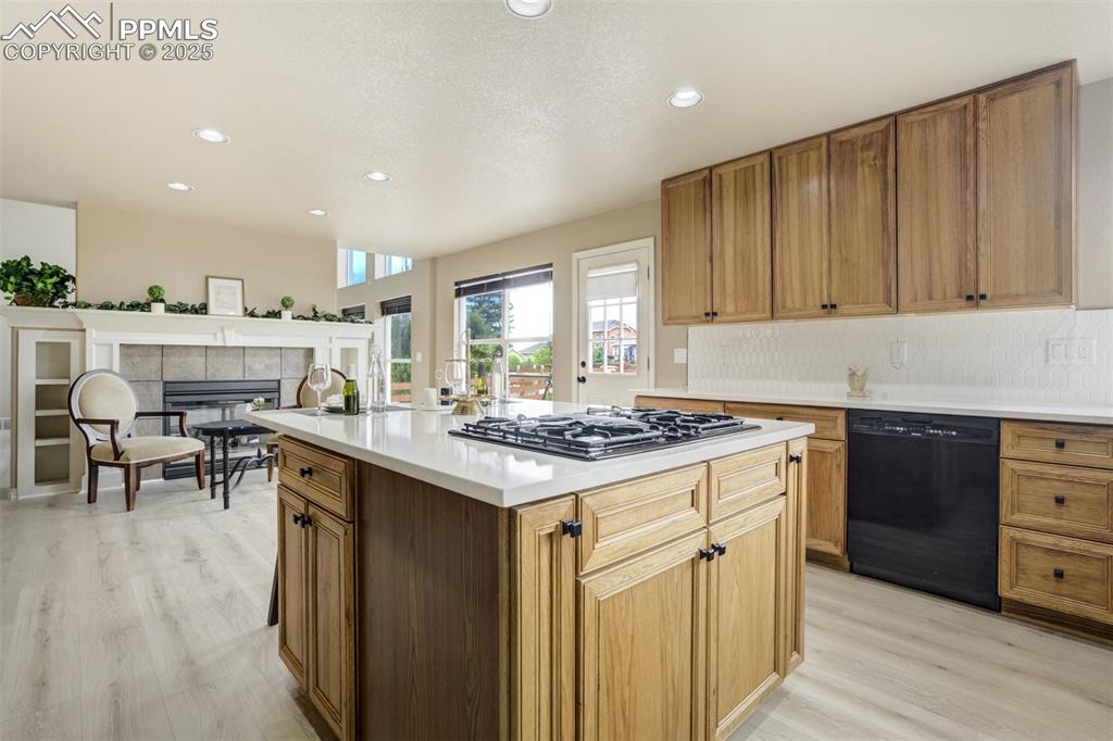 Image 14 of 50: Kitchen featuring black dishwasher, light wood finished floors, gas stoveto