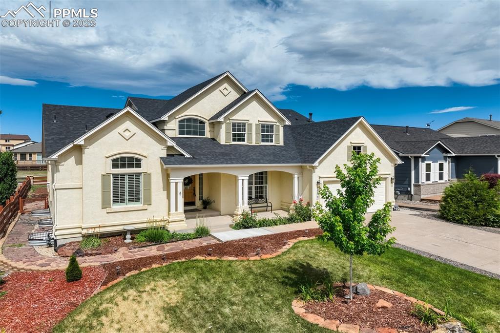 Image 2 of 50: View of front of house with stucco siding, a porch, roof with shingles, con