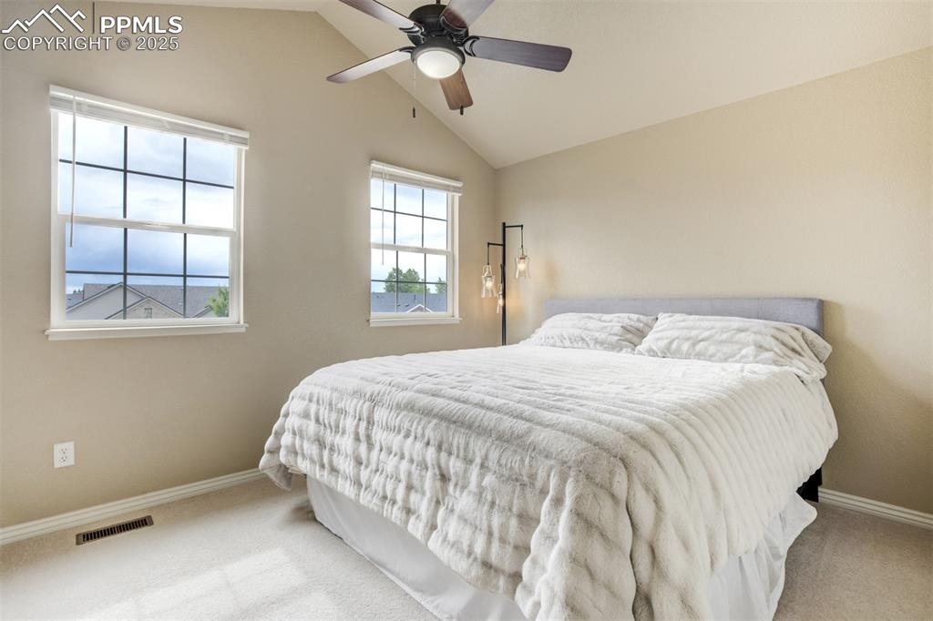 Image 32 of 50: Bedroom featuring carpet, vaulted ceiling, and ceiling fan
