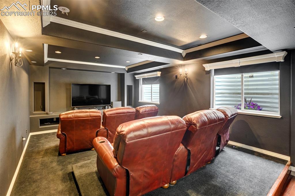 Image 42 of 50: Cinema featuring a raised ceiling, carpet flooring, a textured ceiling, and