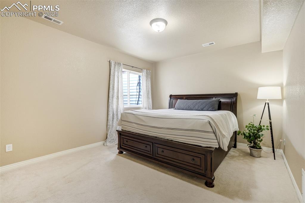 Image 43 of 50: Carpeted bedroom featuring a textured ceiling