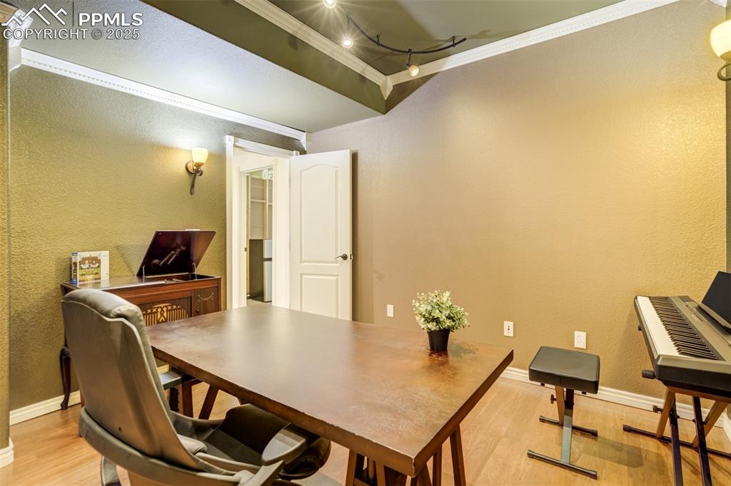 Image 45 of 50: Office area with crown molding, light wood finished floors, a textured wall