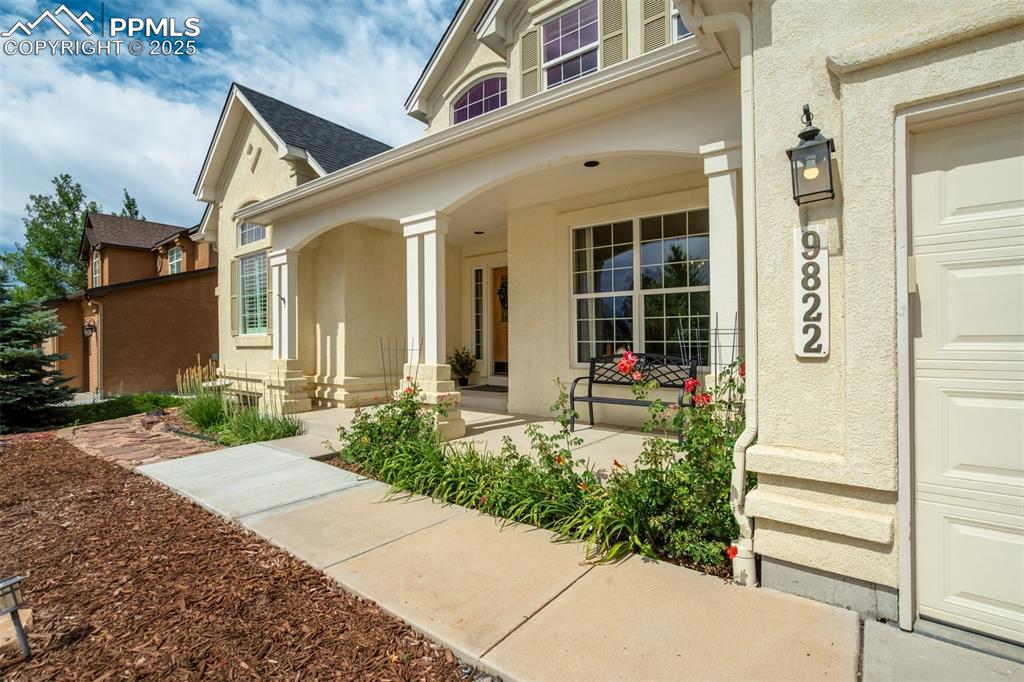 Image 5 of 50: View of exterior entry with a porch and stucco siding