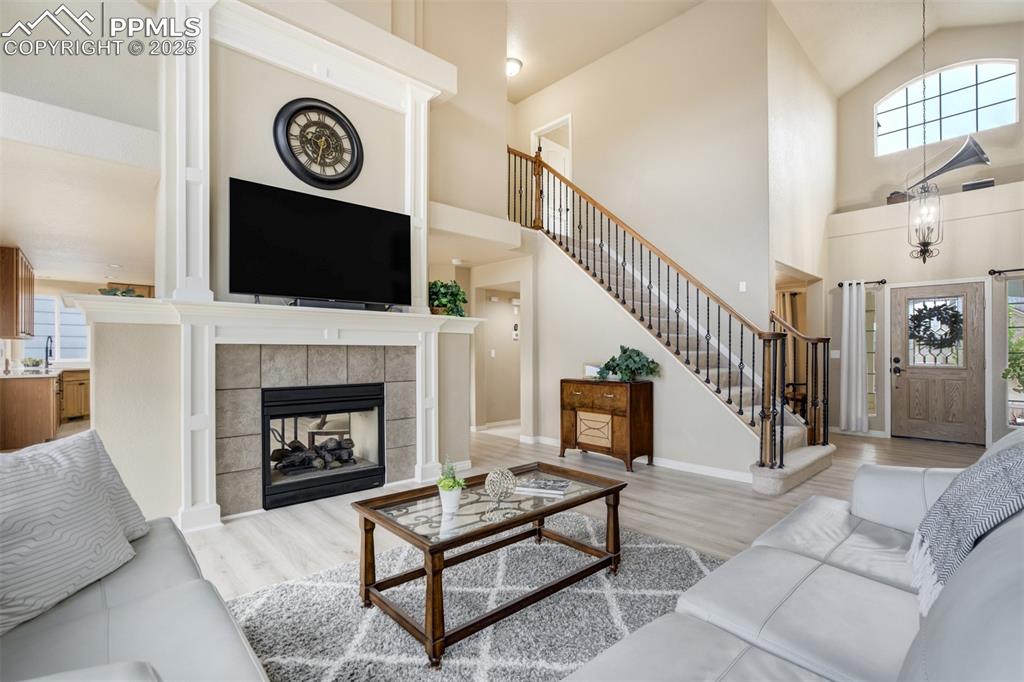 Image 8 of 50: Living room with plenty of natural light, high vaulted ceiling, stairs, and