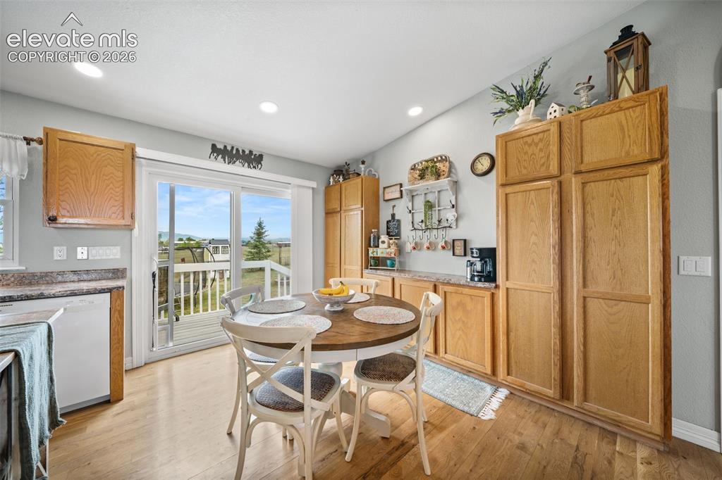 Image 12 of 50: Kitchen dining area featuring wood-finish flooring, light wood cabinetry, r