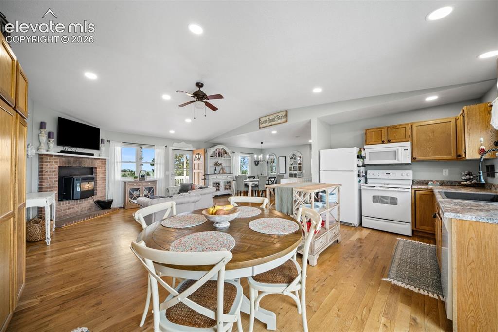 Image 13 of 50: Open-concept living space featuring wood-finish flooring, recessed lighting