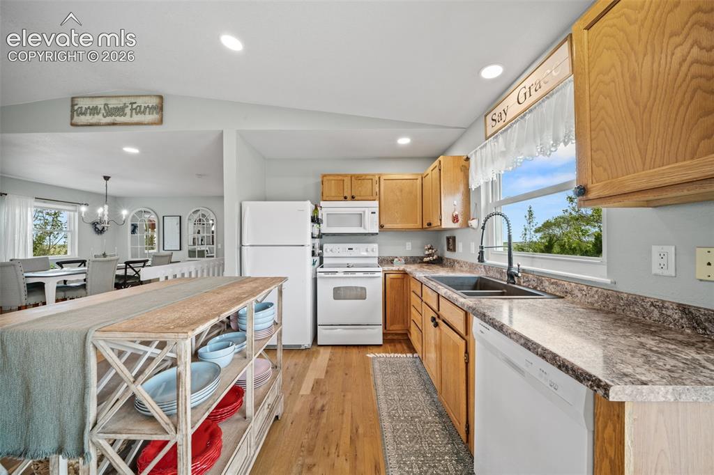 Image 15 of 50: Kitchen featuring wood-finish flooring, recessed lighting, wood cabinetry,