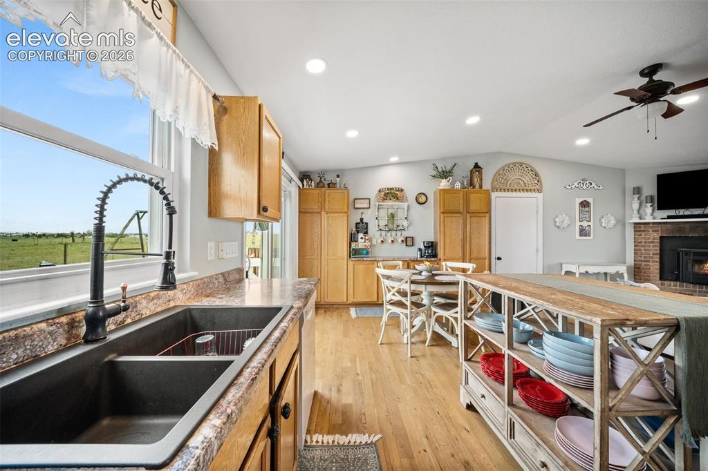 Image 16 of 50: Kitchen featuring a dual basin sink with a black coiled faucet, wood-finish