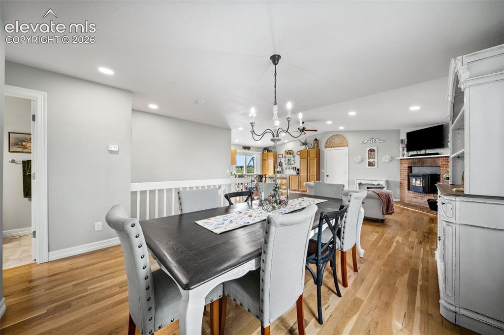 Image 18 of 50: Dining area with wood-finish flooring, recessed lighting, and a chandelier