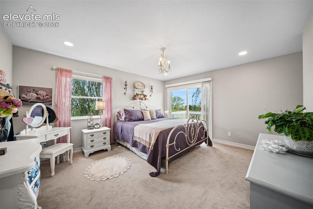 Image 19 of 50: Spacious room with plush carpeting, recessed lighting, and a decorative cha